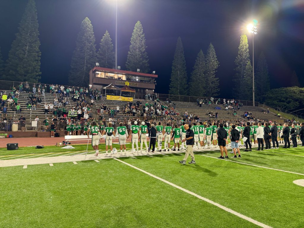 The Konawaena High School football team salutes their boosters after they lost 10-7 in overtime of the First Hawaiian Bank/HHSAA Division I state championship game Saturday night in Mililani. (Rob Collias/Hawaiʻi Journalism Initiative)